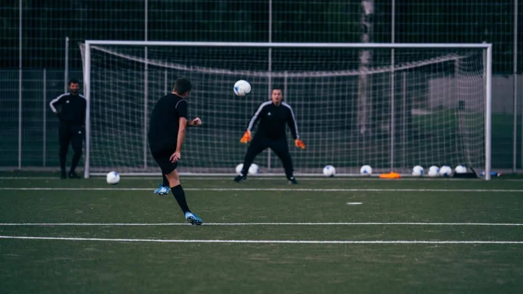 A player shooting at the goalkeeper during an attacking drill